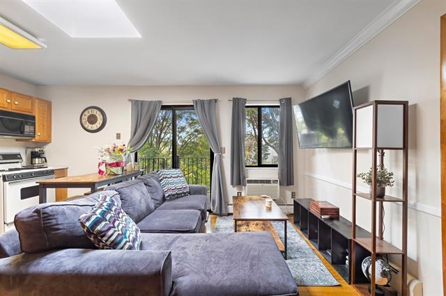 208 1st Street, Unit 5B Hoboken, NJ 07030 - Photo 8 of 11 a living room with furniture and a flat screen tv