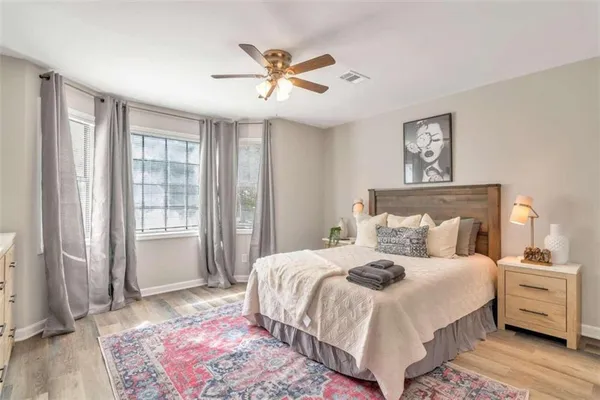 a bedroom with a large bed and a chandelier