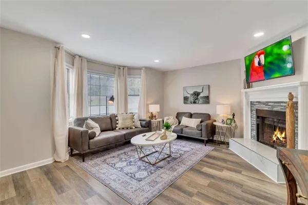 a living room with furniture a flat screen tv and a fireplace