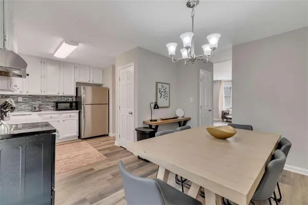 a kitchen with stainless steel appliances a table chairs and refrigerator