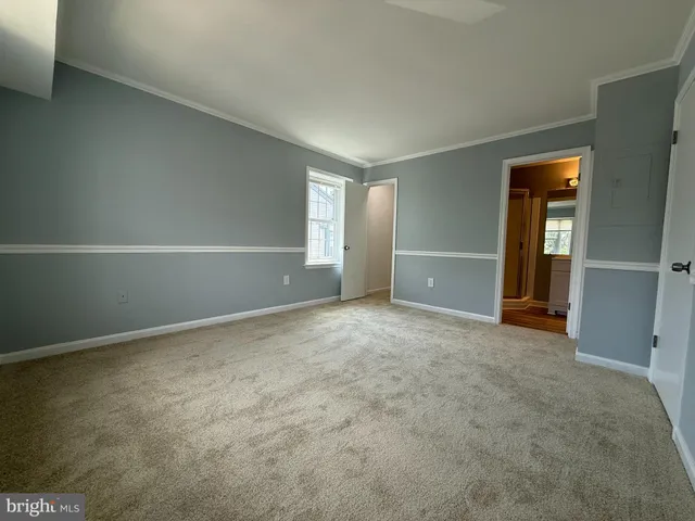 an empty room with closet and mirror