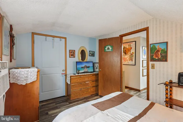 a bedroom with a bed closet and a large window