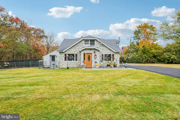 a front view of house with yard and trees in the background