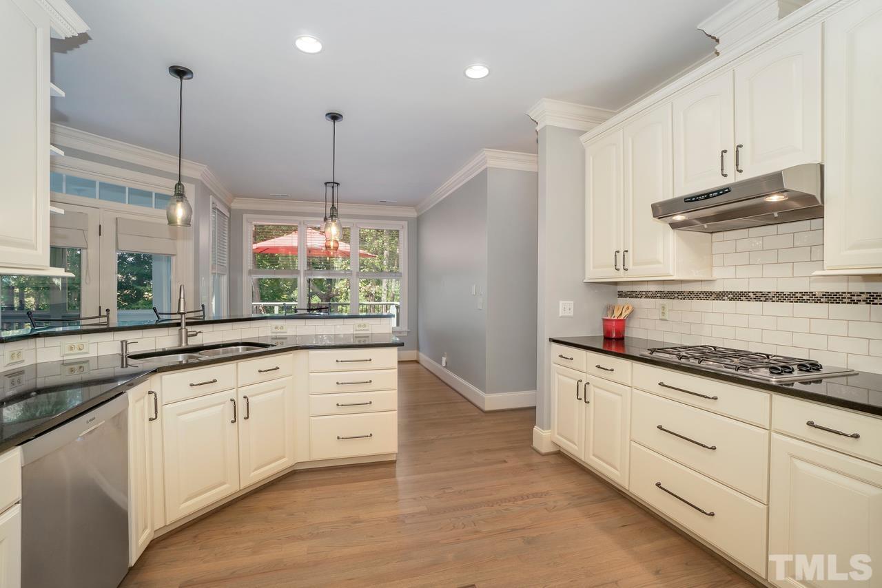 248 Waterville Street Raleigh, NC 27603 - Photo 10 of 30 a kitchen with granite countertop white cabinets and white appliances