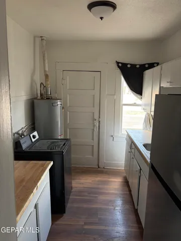 a kitchen with granite countertop a refrigerator and a stove