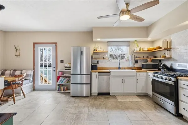 a kitchen that has a lot of cabinets in it and appliances