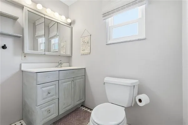 a bathroom with a toilet sink and mirror
