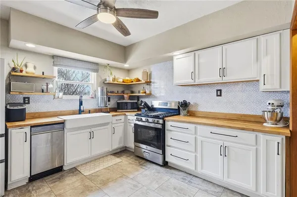 a kitchen with white cabinets stainless steel appliances and sink