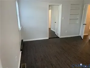 an empty room with wooden floor and closet