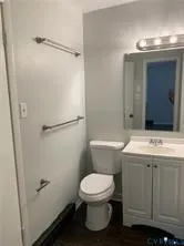 a bathroom with a sink a toilet and shower