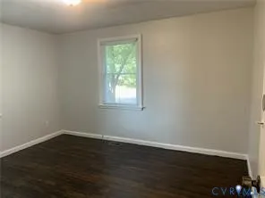 a view of a small space with wooden floor and a window