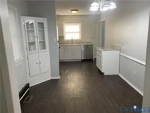 a view of a kitchen with a sink dishwasher wooden floor and a window