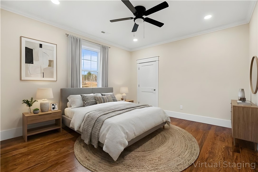 303 Regency Circle Anderson, SC 29625 - Photo 42 of 50 This spacious primary bedroom features rich hardwood floors and abundant natural light, offering a comfortable retreat.