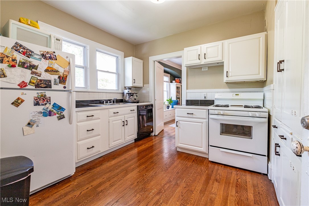 3228 East Fairfax Road Cleveland, OH 44118 - Photo 24 of 49 Kitchen featuring white appliances, hardwood / wood-style floors, and white cabinetry