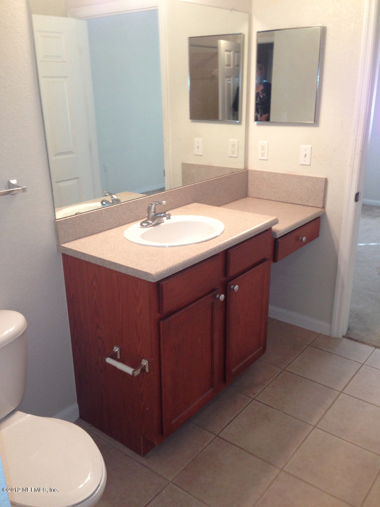 8550 Touchton Road, Unit 717 Jacksonville, FL 32216 - Photo 5 of 15 a bathroom with a sink toilet and mirror