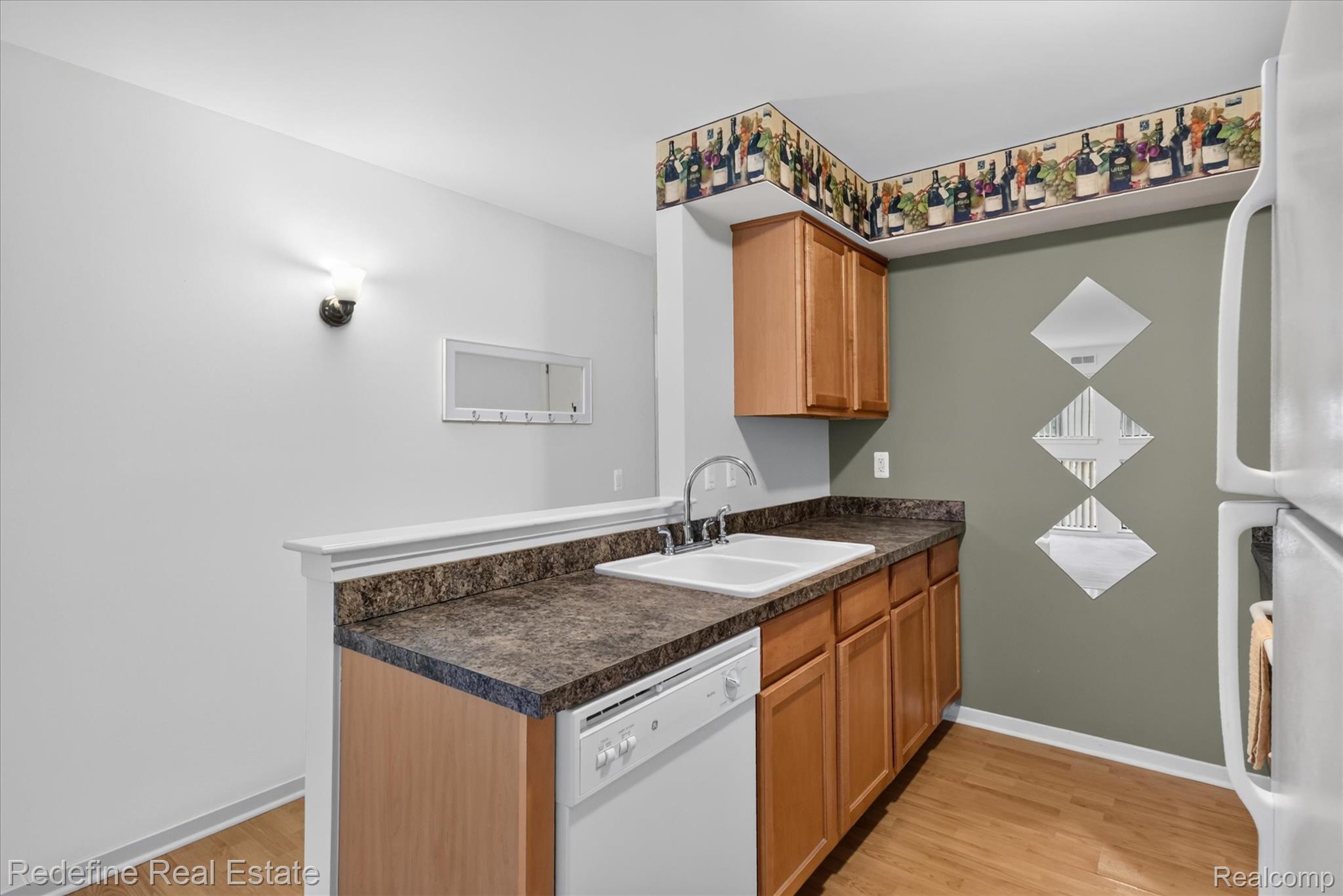 27971 Rollcrest Road, Unit 9 Farmington, MI 48334 - Photo 10 of 25 Kitchen area featuring wood-finish flooring, wood cabinetry, a white dishwasher, white refrigerator, and a double basin sink