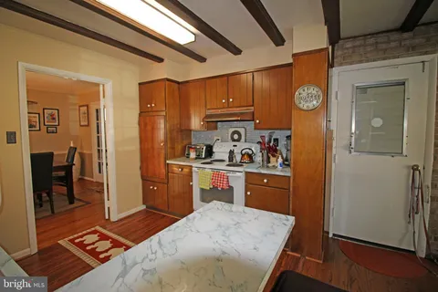 a kitchen with stainless steel appliances granite countertop a refrigerator a sink dishwasher and a stove with wooden floor