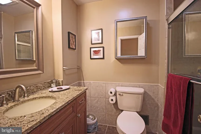 a bathroom with a granite countertop toilet sink and mirror