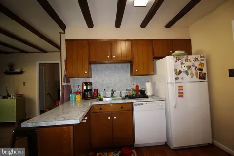 a kitchen with a sink a refrigerator and cabinets