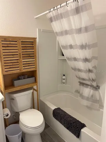 a bathroom with a toilet and a shower