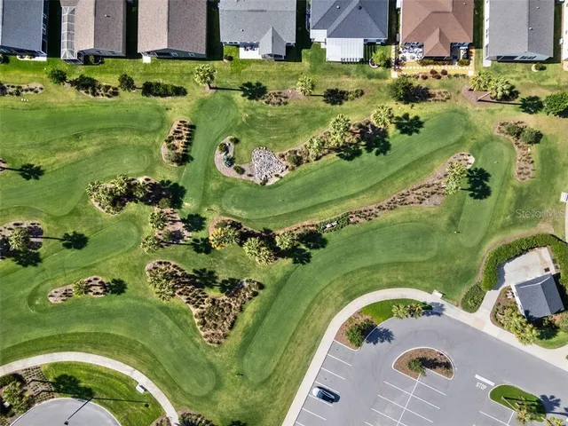 an aerial view of a house with a garden and lake view