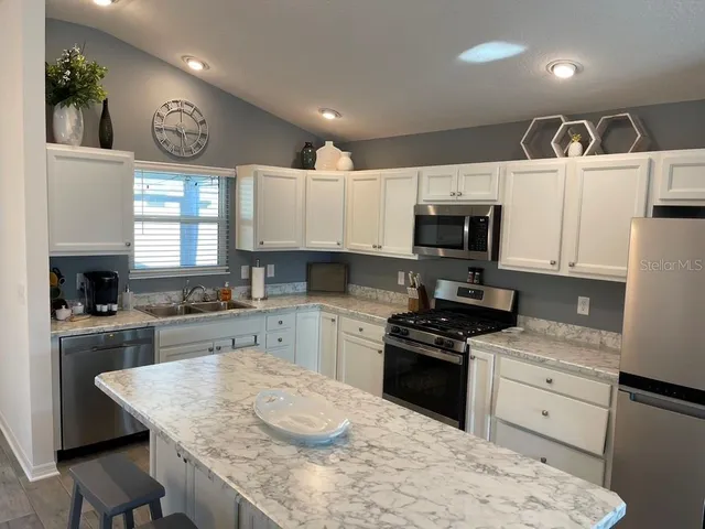 a kitchen with white cabinets and appliances