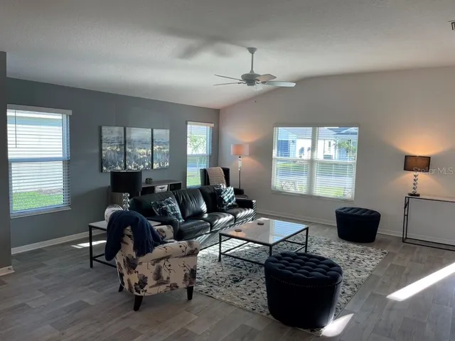 a living room with furniture a chandelier and a window