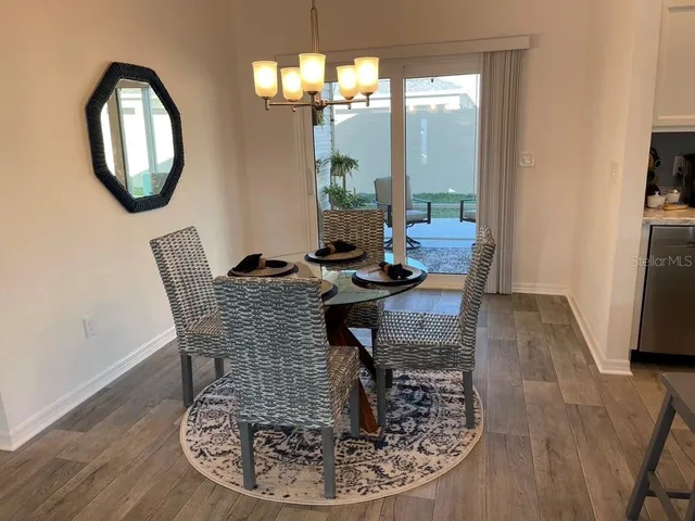 a dining room with wooden floor a glass table and chairs