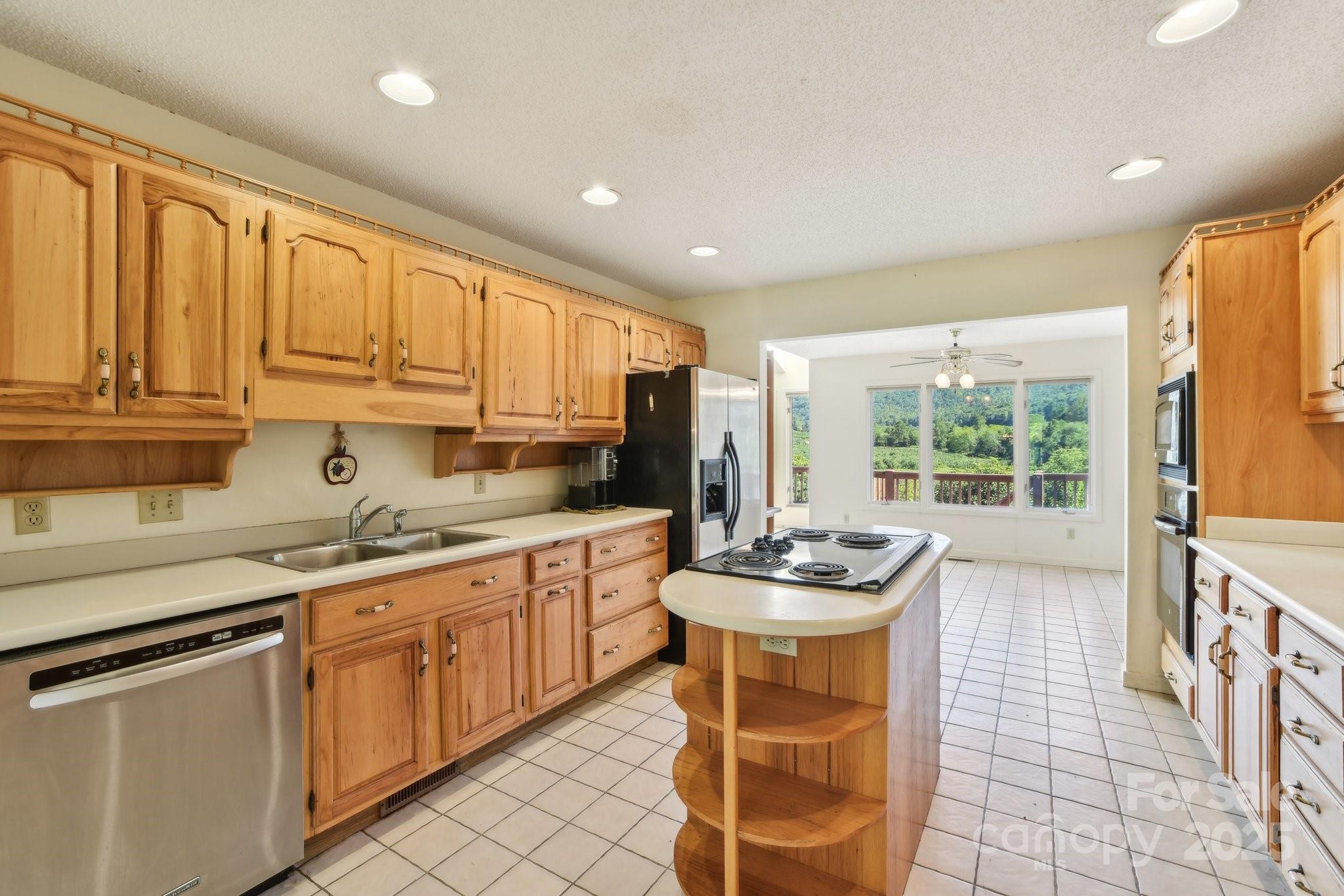2281 Bearwallow Road Hendersonville, NC 28792 - Photo 13 of 46 a kitchen with stainless steel appliances kitchen island granite countertop a sink and cabinets