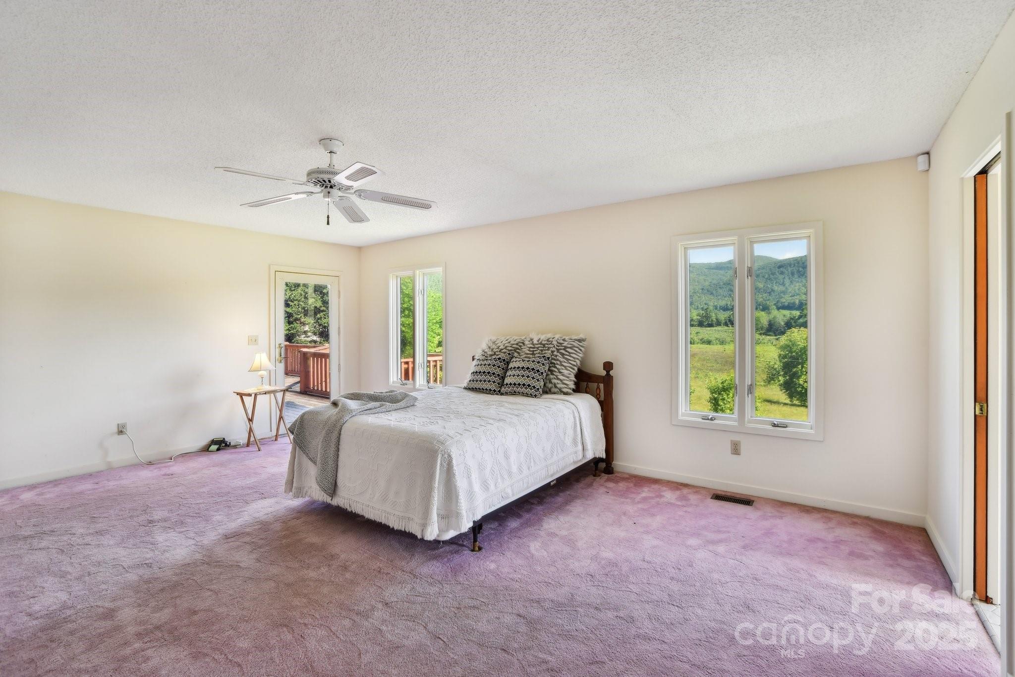 2281 Bearwallow Road Hendersonville, NC 28792 - Photo 15 of 46 a spacious bedroom with a bed and a window
