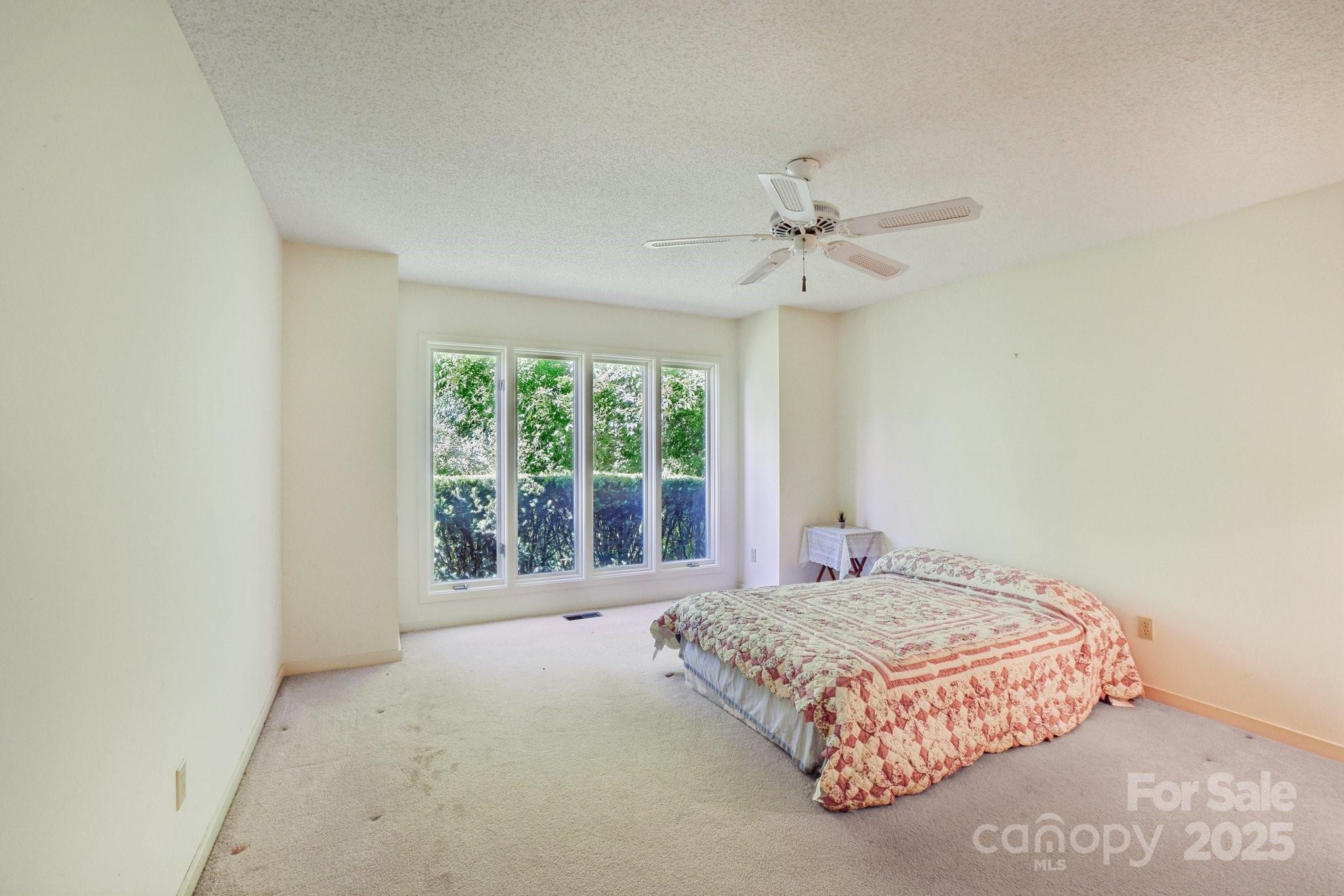 2281 Bearwallow Road Hendersonville, NC 28792 - Photo 19 of 46 a bedroom with a large bed and a chandelier
