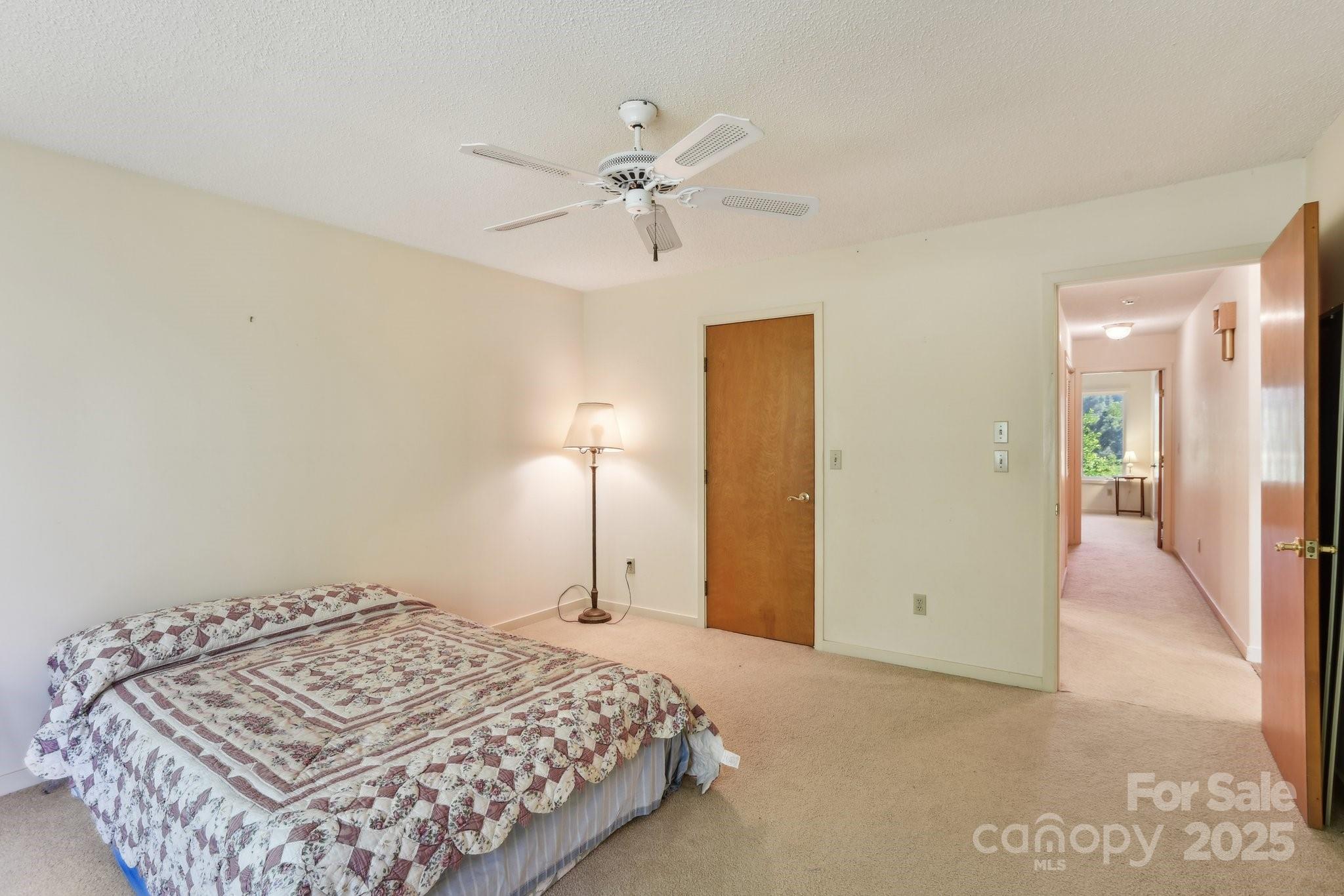 2281 Bearwallow Road Hendersonville, NC 28792 - Photo 20 of 46 a bedroom with a bed and a chandelier