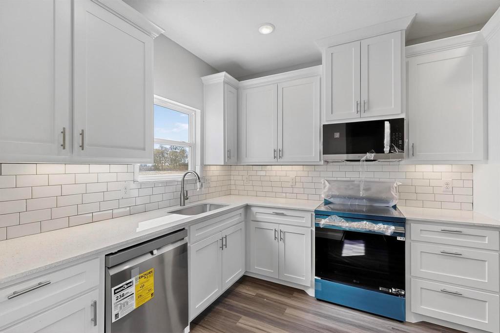 740 Section House Road Ennis, TX 75119 - Photo 13 of 37 a kitchen with stainless steel appliances granite countertop a sink and a stove