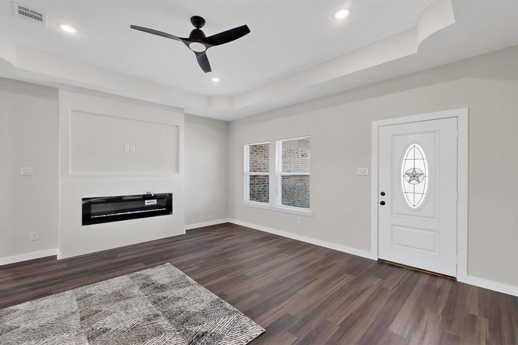 740 Section House Road Ennis, TX 75119 - Photo 7 of 37 a view of a livingroom with wooden floor and a ceiling fan