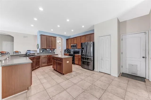 a kitchen with stainless steel appliances granite countertop a refrigerator and a sink