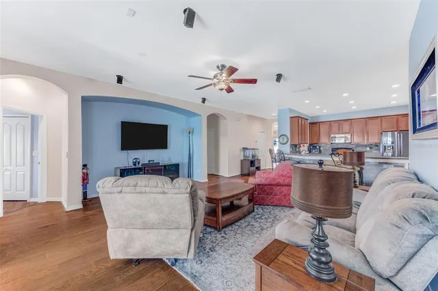 a living room with furniture kitchen view and a flat screen tv