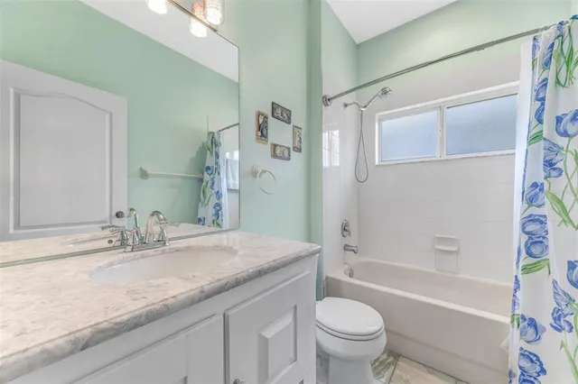 a bathroom with a granite countertop sink a toilet and a bathtub