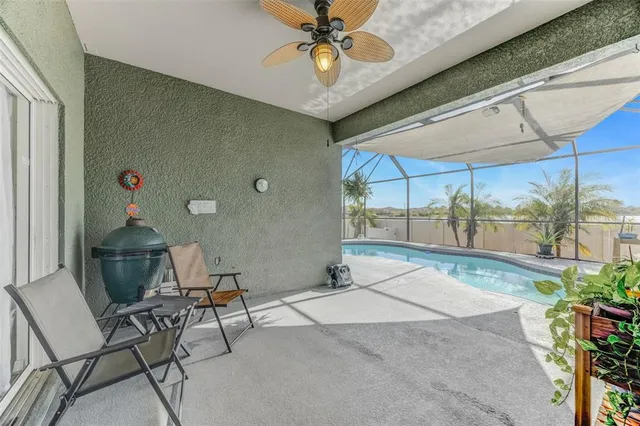 a patio with table and chairs and potted plants