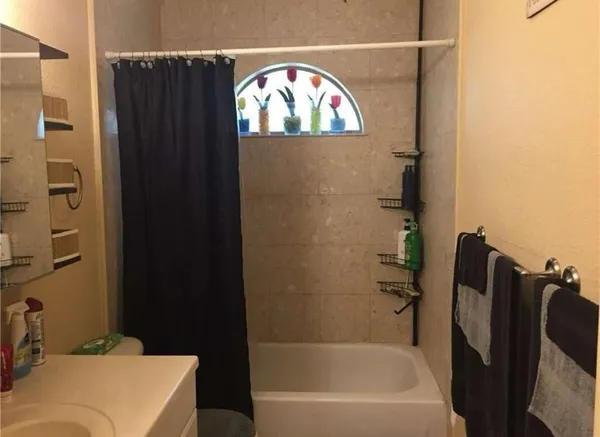 a bathroom with a bathtub and a wooden floor
