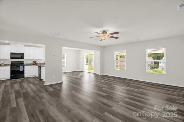 a view of empty room with wooden floor and window