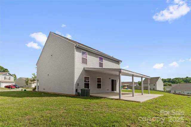 a view of a backyard with plants and large tree