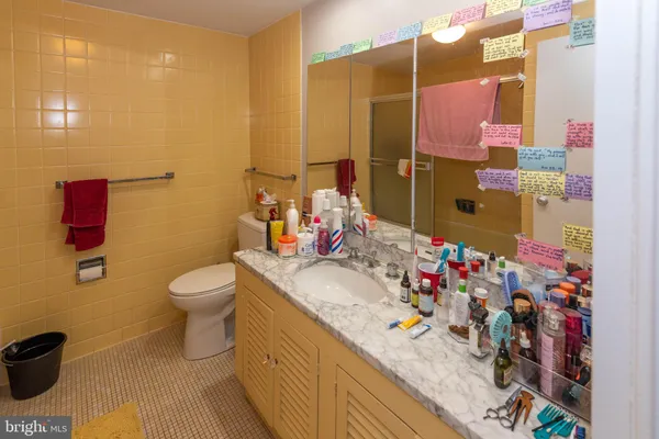 a bathroom with a granite countertop sink a toilet and shower