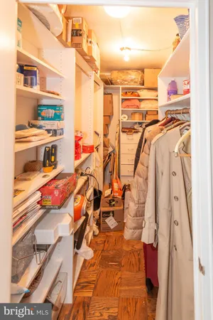 a view of walk in closet with clothes and shoes