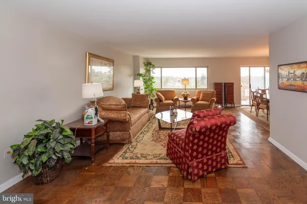 a living room with furniture plant and a large window
