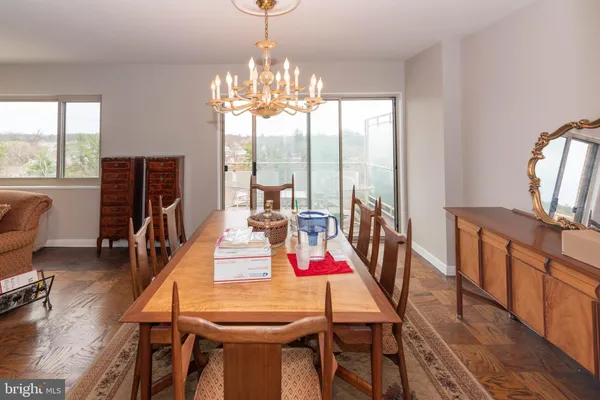 a very nice looking dining room with furniture a chandelier and wooden floor