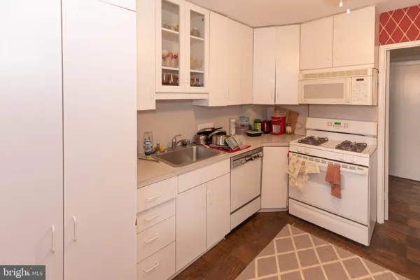 a kitchen with white cabinets and white appliances