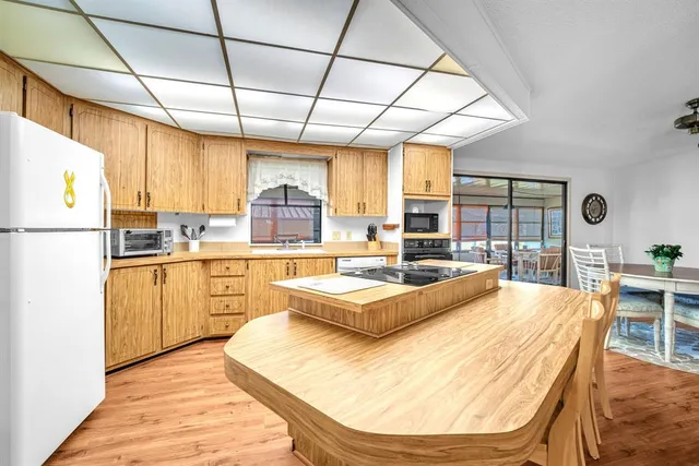 a living room with stainless steel appliances granite countertop furniture and a kitchen view