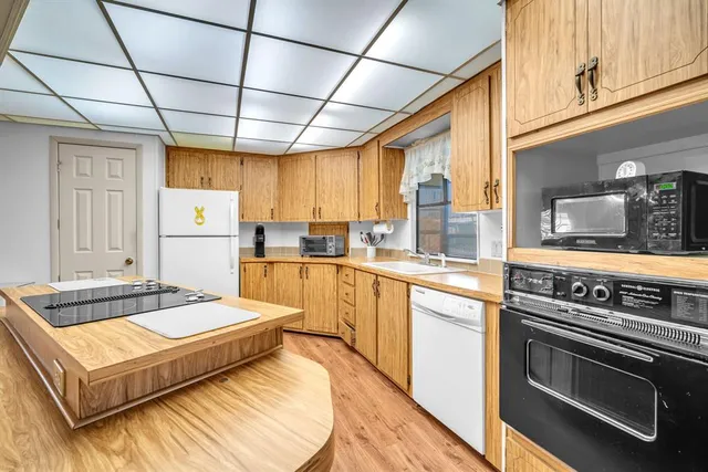 a kitchen with sink stove and refrigerator