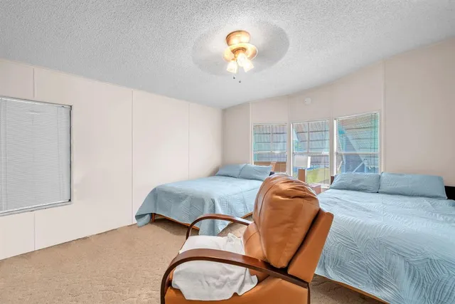 a bedroom with a bed a chandelier and a window