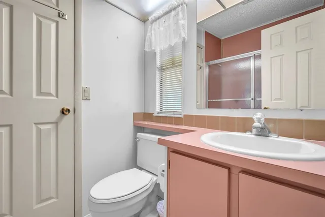a bathroom with a toilet sink vanity and mirror